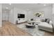 Open living room boasts wood floors and white sectional sofa, with modern decor at 42405 W Peters Dr, Maricopa, AZ 85138