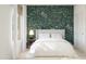 Inviting bedroom with a floral wallpaper, a comfortable bed, and soft natural light creating a relaxing retreat at 42405 W Peters Dr, Maricopa, AZ 85138