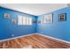 Bright bedroom with light wood floors, a large window, and blue walls for a cheerful and airy atmosphere at 4613 E Shangri La Rd --, Phoenix, AZ 85028