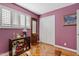 This bedroom is painted in purple and has a brown wooden hall tree, shuttered windows and a closet at 4613 E Shangri La Rd --, Phoenix, AZ 85028