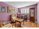 This cozy bedroom is painted purple and has a small wooden table and tan arm chair, and wood laminate flooring at 4613 E Shangri La Rd --, Phoenix, AZ 85028