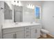 Bright bathroom featuring double sinks, a large mirror, a toilet, and a window at 5311 N 88Th Ave, Glendale, AZ 85305