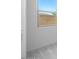 Neutral carpeting and a window with natural light. View of the home's exterior wall at 5311 N 88Th Ave, Glendale, AZ 85305