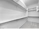 Bright, walk-in closet features shelving, rods, and neutral carpeting, offering ample storage space at 5311 N 88Th Ave, Glendale, AZ 85305