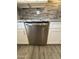 Stainless steel dishwasher in a modern kitchen with white cabinets, gray countertops, and wood-look tile flooring at 5815 N 21St Ave, Phoenix, AZ 85015