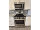 Close-up of a stainless steel gas range and microwave in a kitchen with white cabinets and granite countertops at 5815 N 21St Ave, Phoenix, AZ 85015