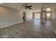 Spacious living room featuring gray walls, wood-look tile flooring, a ceiling fan, and access to the backyard through French doors at 5815 N 21St Ave, Phoenix, AZ 85015