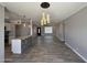 Open-concept living area with modern light fixtures, gray flooring, and a kitchen island with granite countertops at 5815 N 21St Ave, Phoenix, AZ 85015