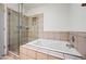 Modern bathroom showcasing a tiled jacuzzi tub and a glass-enclosed shower at 6160 E Inglewood St, Mesa, AZ 85205