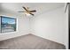 Bright bedroom featuring neutral carpet, ceiling fan, and window letting in natural light at 6160 E Inglewood St, Mesa, AZ 85205