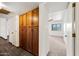 Hallway view with wood cabinets and an open doorway to a carpeted room at 6160 E Inglewood St, Mesa, AZ 85205