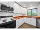 Charming kitchen with white cabinets, wood countertops, and stainless steel appliances at 6160 E Inglewood St, Mesa, AZ 85205