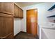 Laundry room with wooden cabinets, washer, and dryer at 6160 E Inglewood St, Mesa, AZ 85205
