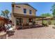 Backyard view from exterior showing covered patio, desert landscaping and two-story home exterior at 630 E Jensen St # 102, Mesa, AZ 85203