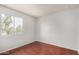 Empty bedroom with hardwood floors, a window providing natural light, and neutral-toned walls at 630 E Jensen St # 102, Mesa, AZ 85203
