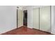 Empty bedroom featuring hardwood floors and ample closet space with sliding doors at 630 E Jensen St # 102, Mesa, AZ 85203