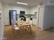 Modern kitchen with white cabinets, stainless steel appliances, and a light wood dining table at 720 S Dobson Rd # 95, Mesa, AZ 85202