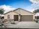 Charming single-story home featuring a two-car garage, stone accents, and a well-manicured front yard at 793 W Riparian Dr, San Tan Valley, AZ 85140