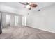 Large carpeted bedroom featuring a ceiling fan, walk-in closet, and bathroom access at 810 W Villa Maria Dr, Phoenix, AZ 85023