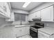 Bright kitchen featuring white cabinets, granite countertops, and stainless-steel appliances at 810 W Villa Maria Dr, Phoenix, AZ 85023