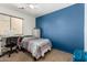 Bedroom with blue accent wall, carpet floors and a cozy bed with colorful quilt at 829 S 111Th Dr, Avondale, AZ 85323