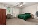 Bright bedroom with neutral carpet, ceiling fan, window with natural light and green comforter at 829 S 111Th Dr, Avondale, AZ 85323