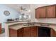 Functional kitchen showcasing wood cabinetry, stainless steel sink and eat-in bar space at 829 S 111Th Dr, Avondale, AZ 85323