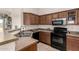 Functional kitchen featuring wood cabinetry, stainless steel appliances, and neutral countertops at 829 S 111Th Dr, Avondale, AZ 85323