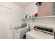 Functional laundry room featuring modern washer and dryer with shelving for storage at 829 S 111Th Dr, Avondale, AZ 85323