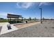 Wide shot of a community common area including a picnic pavilion, bocce ball court and lush landscaping at 848 W Riparian Dr, San Tan Valley, AZ 85140