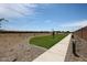 Community landscape featuring a walking path with desert plants, a small green lawn, and a nearby privacy wall at 848 W Riparian Dr, San Tan Valley, AZ 85140