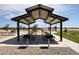Community pavilion with picnic tables and built-in grills, set near a playground for Gathering enjoyment at 848 W Riparian Dr, San Tan Valley, AZ 85140
