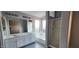 Bright bathroom with double sinks, large mirror, soaking tub, and glass-enclosed shower at 8582 W Rue De Lamour --, Peoria, AZ 85381