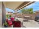 Covered patio with red cushioned chairs, table, and view of pool and backyard with block fence at 8948 W Fargo Dr, Peoria, AZ 85382