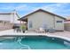 Backyard pool with a patio featuring outdoor seating, a rock surround, and the home's exterior at 8948 W Fargo Dr, Peoria, AZ 85382