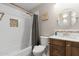 Full bathroom with shower and tub combination, single sink vanity, decorative mirror, and tiled accent wall at 8948 W Fargo Dr, Peoria, AZ 85382