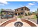 Backyard with a fire pit, pergola, and two story home at 13313 W Indianola Ave, Litchfield Park, AZ 85340