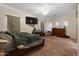 Spacious bedroom features a mounted television, work space, and neutral color palette at 13313 W Indianola Ave, Litchfield Park, AZ 85340