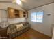 Bright bedroom with wood floors, built-in cabinets, and a comfortable-looking sofa at 1426 S Havasupai Dr, Apache Junction, AZ 85119