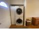 Convenient laundry area equipped with a stacked washer and dryer unit and door at 1426 S Havasupai Dr, Apache Junction, AZ 85119