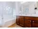 Well-lit bathroom featuring a double vanity, ample storage, tub, and natural light at 1453 W Birch Rd, San Tan Valley, AZ 85140