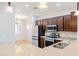 Well-lit kitchen with stainless steel appliances, granite counters, and dark wood cabinets at 1453 W Birch Rd, San Tan Valley, AZ 85140