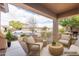 Cozy covered patio with comfortable woven seating and views of the landscaped front yard at 1453 W Birch Rd, San Tan Valley, AZ 85140