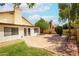 A backyard with grass, brick patio, trees, and a building with white French doors to the home's interior at 1601 E Cindy St, Chandler, AZ 85225