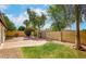 An enclosed backyard with a brick patio, lush green lawn, and mature trees for enhanced privacy at 1601 E Cindy St, Chandler, AZ 85225