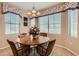 A charming dining area with a round wooden table, seating for four, and bright natural light at 17009 W Eureka Springs Dr, Surprise, AZ 85387