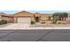 Inviting single-story home with desert landscaping, mature trees, and a well-kept lawn at 17009 W Eureka Springs Dr, Surprise, AZ 85387
