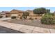 Charming home exterior with low-maintenance landscaping and a well-manicured lawn at 17009 W Eureka Springs Dr, Surprise, AZ 85387