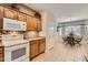 Functional kitchen featuring white appliances, oak cabinets, and tiled flooring, with an adjacent dining area for convenient meals at 17009 W Eureka Springs Dr, Surprise, AZ 85387