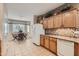 Well-lit kitchen with light wood cabinets, a white refrigerator, and a view of the adjacent dining area, ideal for casual meals at 17009 W Eureka Springs Dr, Surprise, AZ 85387